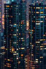 A closeup of skyscrapers in a city during nighttime using a telephoto lens