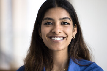 Cheerful beautiful young Indian woman with white teeth and nose stud close up head shot. Happy attractive 20s girl looking at camera, smiling, posing for close video call screen portrait