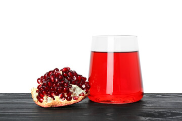 Refreshing pomegranate juice in glass and fruit on black wooden table against white background