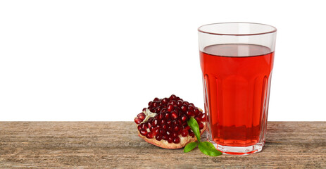 Refreshing pomegranate juice in glass, leaves and fruit on wooden table against white background. Space for text