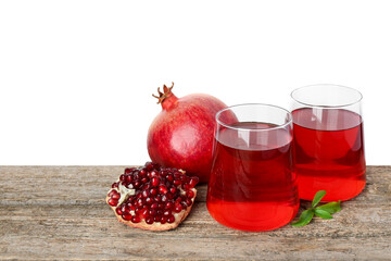 Refreshing pomegranate juice in glasses, leaves and fruits on wooden table against white...