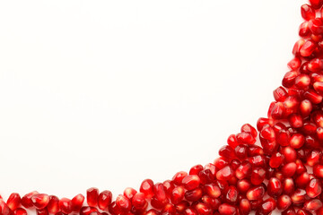 Many ripe juicy pomegranate grains on white background, flat lay. Space for text