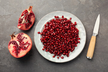 Tasty ripe pomegranate and grains on grey table, flat lay