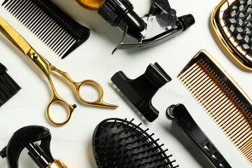 Hairdressing tools on white table, flat lay