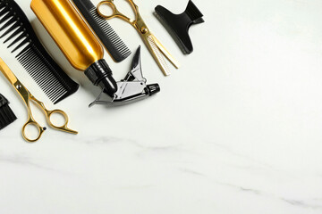 Hairdressing tools on white marble table, flat lay. Space for text