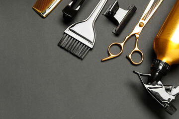 Hairdressing tools on dark table, flat lay. Space for text