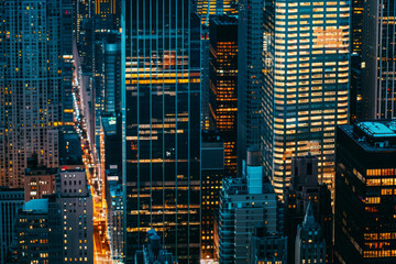 A closeup of skyscrapers in a city during nighttime using a telephoto lens