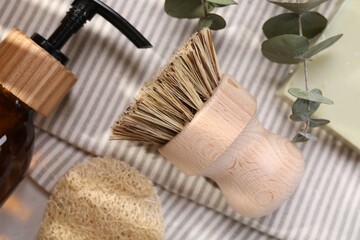 Cleaning brush, sponge, dispenser and eucalyptus leaves on table, top view
