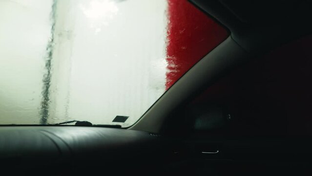 Inner Radiance: Witness the transformation of your car as it emerges from the automatic car wash, its exterior gleaming with newfound radiance, captured from inside for a front-row seat to the