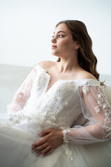 young beautiful woman in white wedding dress with long curly hair