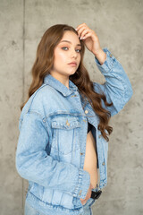 beautiful young woman with long hair in jeans and jacket posing