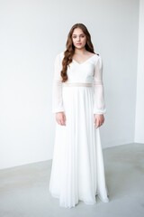 portrait of beautiful young woman in white wedding dress posing in studio.