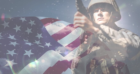 Image of snow falling over caucasian male soldier and flag of usa