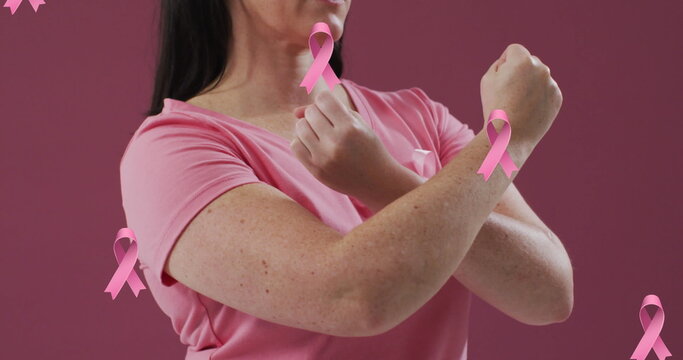 Image of pink ribbons over caucasian woman with pink ribbon on pink background
