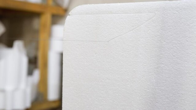 Close-up of precision cut on white polystyrene foam material in factory