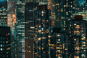 A closeup of skyscrapers in a city during nighttime using a telephoto lens