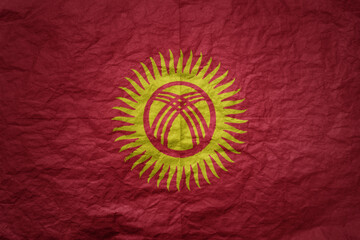 big national flag of kyrgyzstan on a grunge old paper texture background