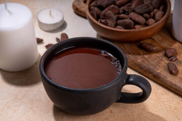 Ceremonial Cacao drink. Hot ceremonial chocolate in black cup with cocoa beans. Woman hands holding cocoa mug. Organic healthy chocolate drink prepared from beans, without creamer, sugar or toppings - 785295190