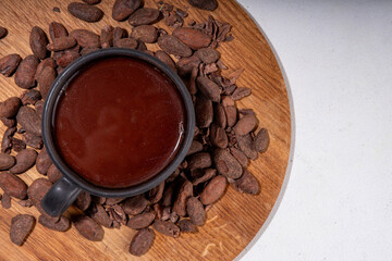 Ceremonial Cacao drink. Hot ceremonial chocolate in black cup with cocoa beans. Woman hands holding cocoa mug. Organic healthy chocolate drink prepared from beans, without creamer, sugar or toppings - 785296119