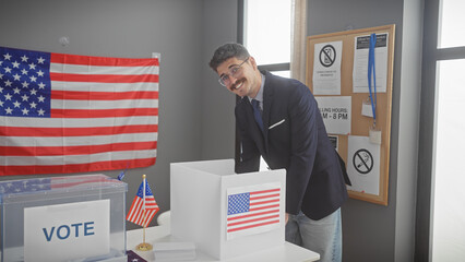 A young hispanic man in a suit smiles as he participates in a vote at a united states polling...