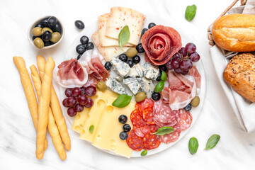 Italian food antipasto prosciutto ham, salami, olives and grissini breadsticks. cheese on a board...