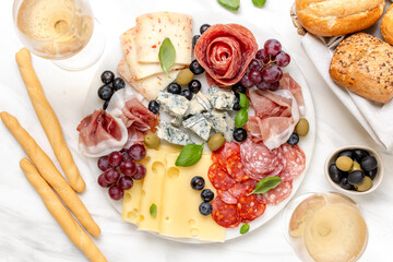 Italian food antipasto prosciutto ham, salami, olives and grissini breadsticks. cheese on a board...