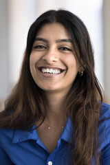 Happy positive attractive 20s Indian vertical portrait. Joyful beautiful young woman in casual cloth with healthy white teeth and long hair girl looking at camera with perfect toothy smile