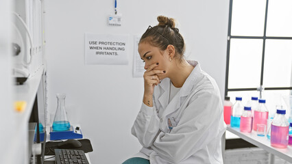 Intriguing portrait, a young beautiful hispanic woman scientist, deep in thought, working with data...