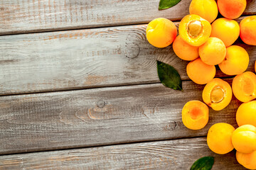 Fruit background with apricots and leaves on dark wooden background top view copy space