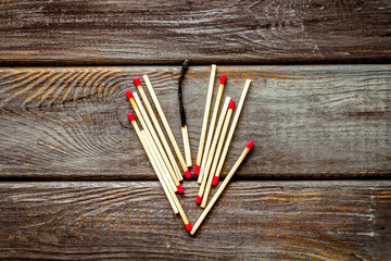 Symbol of danger with matches on wooden background top view
