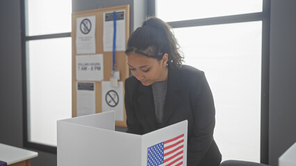 A young hispanic woman in professional attire attentively participates in an event at an american...
