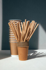 A set of paper utensils and wooden cutlery on a gray background. Eco friendly, zero waste concept. Front view