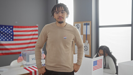 Man and woman in a voting center with american flags, portraying participation in us democracy.