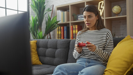 Focused hispanic woman playing video games in a cozy living room setup