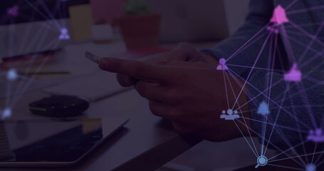 Image of web of connections with icons floating over hands of a man using a smartphone