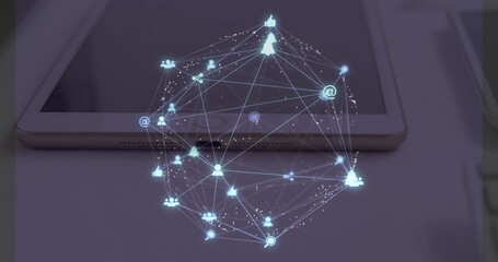 Image of web of connections with icons floating over a desk with a laptop, tablet and smartphone