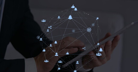 Image of web of connections with icons floating over hands of a man using a digital tablet