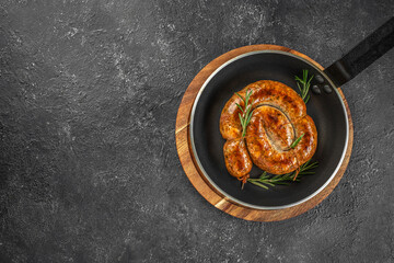 Snail sausage, Roasted sausage in pan on a dark background. top view. copy space for text