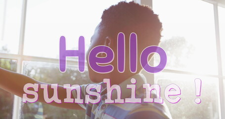 Image of hello sunshine text in purple over african american boy drawing curtains on sunny day
