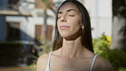 Young beautiful hispanic woman finds balance and freedom, breathing in fresh air, fully immersed...