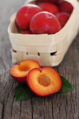 Fresh red plums on wooden background