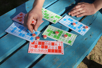 Lotto board game for friends and family. bingo. retro cards of bright different colors with numbers lie on a blue wooden surface