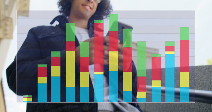 Image of colourful graph over smiling biracial man using smartphone in street