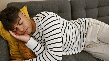 Attractive, young hispanic man found comfortable relaxation, sleeping soundly on the cozy sofa,...
