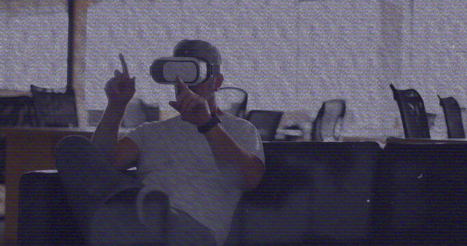 Image of vhs glitch effect over caucasian man wearing vr headset at office - Powered by Adobe