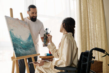 loving cheerful couple of bearded man and disabled woman painting on easel together at home