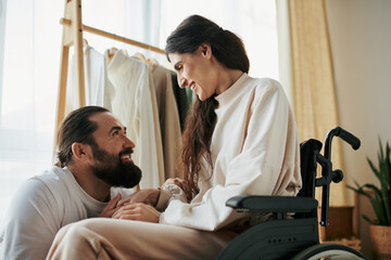 attractive cheerful man spending time with his beautiful disabled wife while in bedroom at home - obrazy, fototapety, plakaty