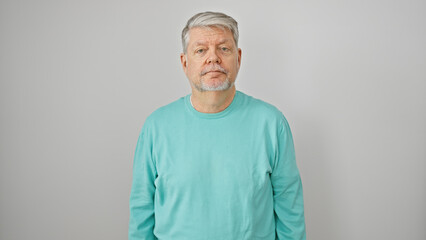 Portrait of a grey-haired man in casual attire against a white background looking at the camera.