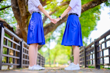 friendship schoolgirl in thai student secondary school uniform walk together outdoor in park