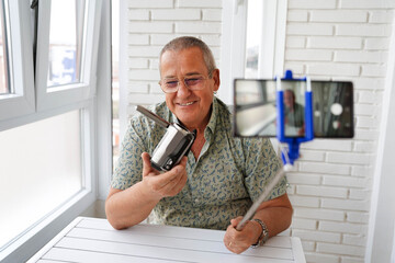 Mature man streaming while holding a video camera